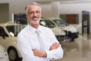 Smiling businessman standing with arms crossed