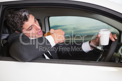 Man drinking coffee and eating donnut on phone