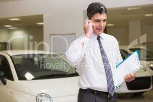 Businessman on the phone holding folder