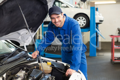 Mechanic examining under hood of car