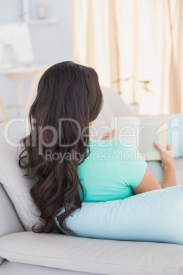 Woman reading book on couch