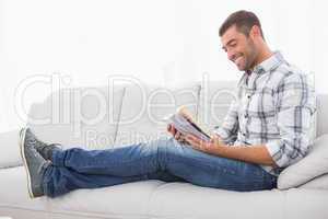 Relaxing man on a sofa with a book