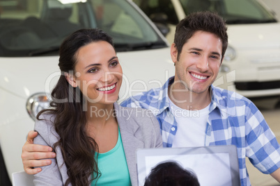 Smiling couple buying a new car