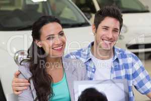 Smiling couple buying a new car