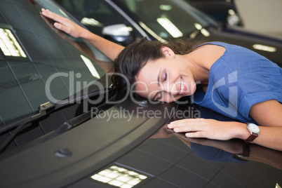 Smiling woman hugging a black car