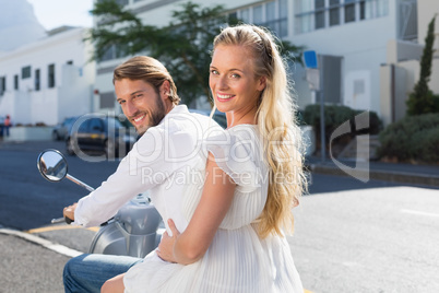 Attractive couple riding a scooter