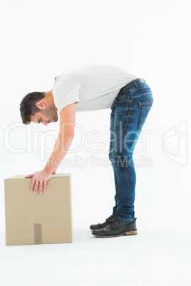 Side view of delivery man picking cardboard box