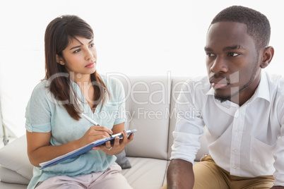 Therapist taking notes on her patient