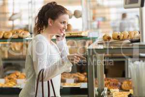 Pretty brunette picking out a pastry