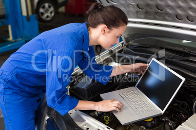 Mechanic using laptop on car