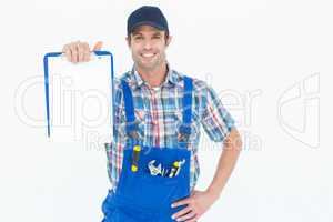 Confident plumber showing blank clipboard