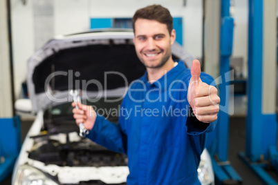 Mechanic holding pair of wrenches