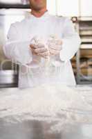 Close up of bakers hands holding flour