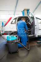 Mechanic vacuuming the car interior