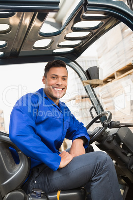 Driver operating forklift machine in warehouse