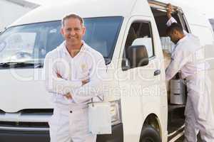 Painter smiling leaning against his van
