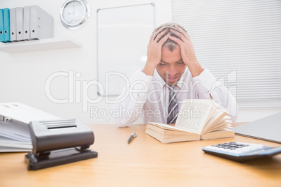 Stressed businessman with head in hands