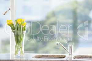 Yellow flower in a vase on the sink