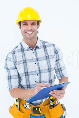 Happy architect writing notes on clip board