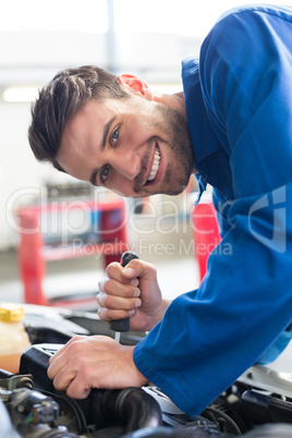 Mechanic using screwdriver on engine