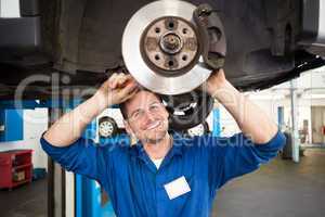 Smiling mechanic adjusting the wheel