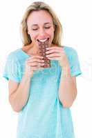 Happy blonde eating bar of chocolate