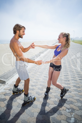 Fit couple rollerblading together on the promenade