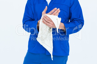 Cropped image of mechanic wiping hand with napkin