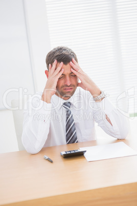 Stressed businessman with head in hands