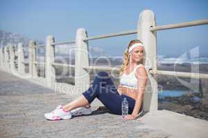 Fit blonde sitting on the pier