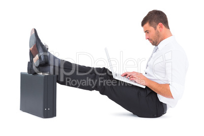 Businessman with feet up on briefcase