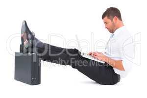 Businessman with feet up on briefcase