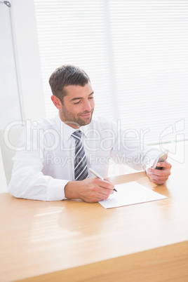 A businessman writing at his desk