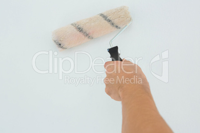 Mans hand using paint roller