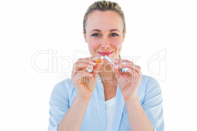 Smiling blonde standing and breaking cigarette