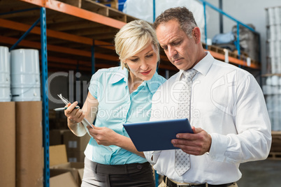 Warehouse managers looking at tablet pc