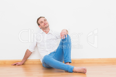 Thoughtful casual man relaxing on the floor