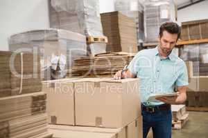 Warehouse worker checking his list on clipboard