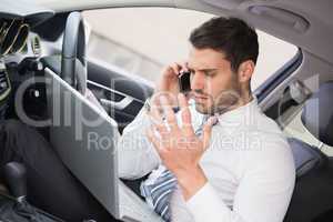 Businessman working in the drivers seat