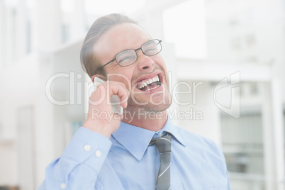 Happy businessman on the phone laughing