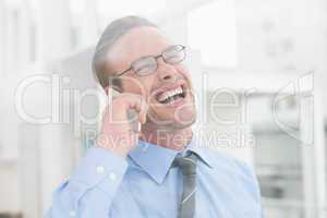 Happy businessman on the phone laughing