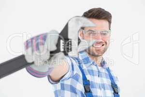 Handyman wearing protective glasses while holding wrench