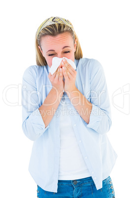 Casual blonde blowing nose on tissue
