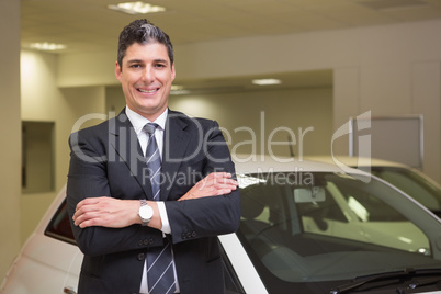 Smiling businessman standing with arms crossed