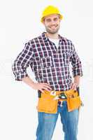 Handyman wearing tool belt while standing hands on hips