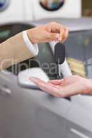 Businesswoman giving car key to happy customer