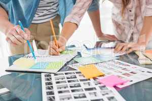 Colleagues writing notes and editing photos