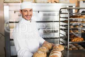 Happy baker showing tray of fresh bread