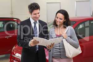 Salesman showing brochure to customer and smiling