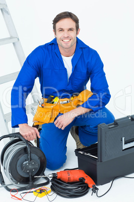 Confident electrician with tools